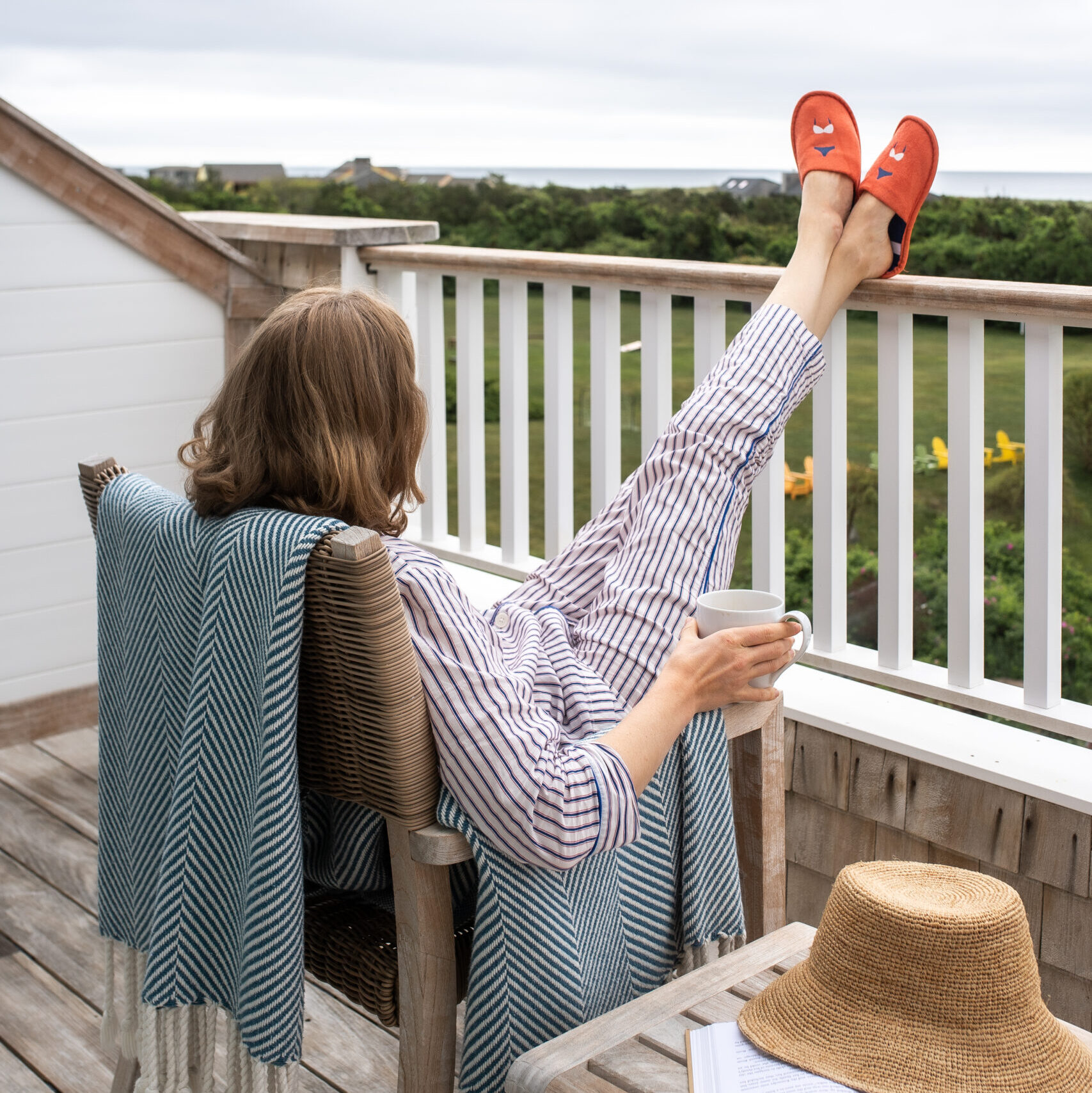 A woman on a deck with her feet on the railing
